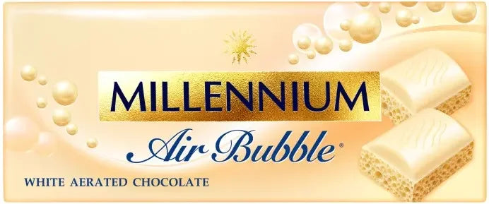 На упаковці білого пористого шоколаду Millennium Air зображено золотий та кремовий кольори, плаваючі бульбашки та два шматочки шоколаду з пористою текстурою. Текст підкреслює білий пористий шоколад та вершковий смак.