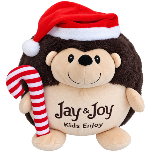 Jay&Joy Іграшка Їжачок — новорічна плюшева іграшка у вигляді їжачка в шапці Діда Мороза, який тримає червоно-білу смугасту цукерку-паличку.