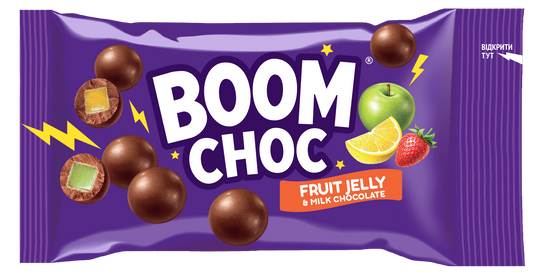 На яскравій фіолетовій упаковці з написом «BOOM CHOC» зображені шоколадні кульки поруч із зеленим яблуком, лимоном та полуницею, що підкреслює назву продукту «Драже BOOM CHOC Мармелад у молочному шоколаді». На упаковці зображено поперечні зрізи з кольоровою желейною начинкою та напис «Fruit Jelly & Milk Chocolate» (молочний шоколад), що робить її ідеальним солодким перекусом із мармеладом у шоколаді.