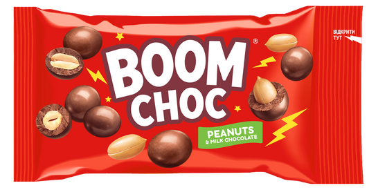 На червоній обгортці з написом «BOOM CHOC» зображені арахіс у молочному шоколаді та цілі горіхи, а також зелена етикетка з написом «Peanuts & Milk Chocolate» і жовті блискавки в якості прикраси. Це продукт «Драже BOOM CHOC Арахіс у молочному шоколаді» від бренду BOOM CHOC.