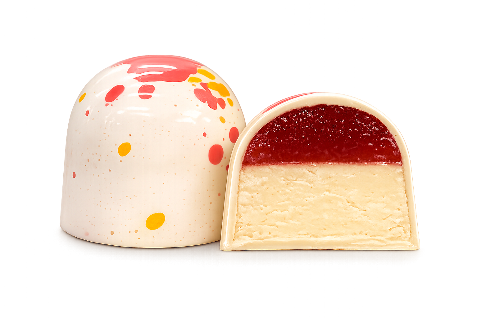 Кондитерський виріб у формі купола з білого шоколаду — «Millennium Craft Strawberry & Lemon with Stevia» від Millennium Chocolate — прикрашений червоними та жовтими бризками; на фото він зображений цілим та розрізаним навпіл, що дозволяє побачити шар полуничного мармеладу поверх кремової білої начинки.